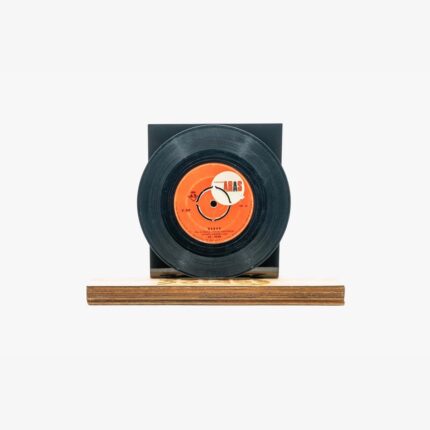 Black vinyl record with an orange label mounted on a black display stand atop a wooden base.