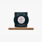 2301450032B | 3345 Records Black vinyl record mounted on a wooden base with a dark rectangular backing behind it.