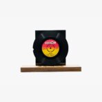 2301450049D | 3345 Records Black vinyl record mounted on a rectangular black display block atop a wooden base. (Studio shot)