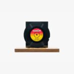 2301450049E | 3345 Records Black vinyl record mounted on a wooden base with a colorful red‑yellow center label on display.