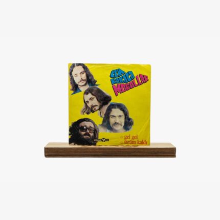 Yellow album cover with four band members’ portraits on a bright background, placed on a wooden base.